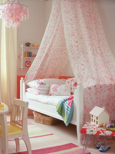 cozy-girl-bedroom-with-high-canopy-draped-over-a-bed.jpg