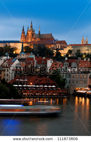 stock-photo-prague-castle-with-surrounding-buildings-across-vltava-river-in-the-evening-111873806.jpg